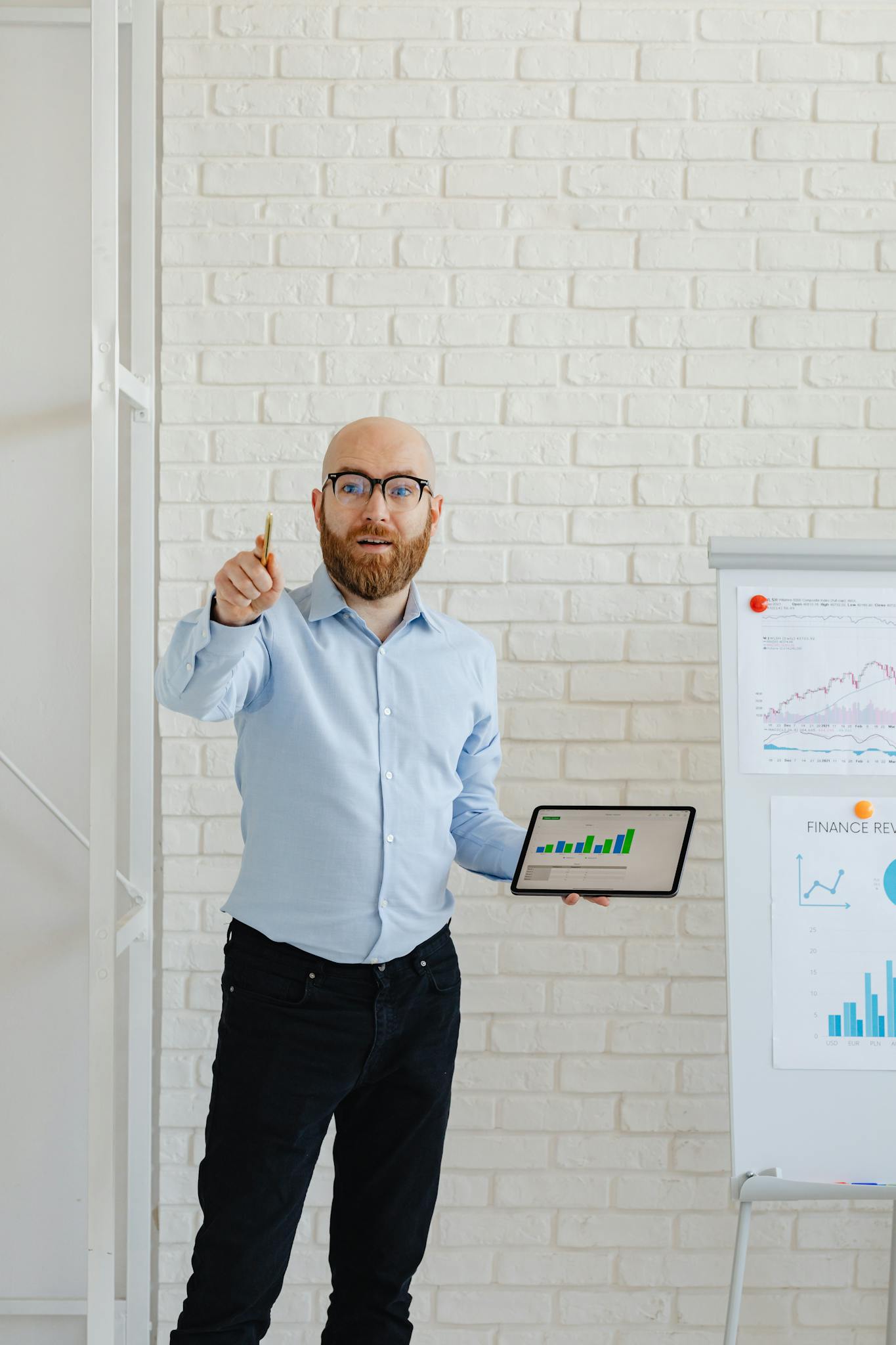 A businessman presents growth charts using a tablet and flipchart in an office setting.